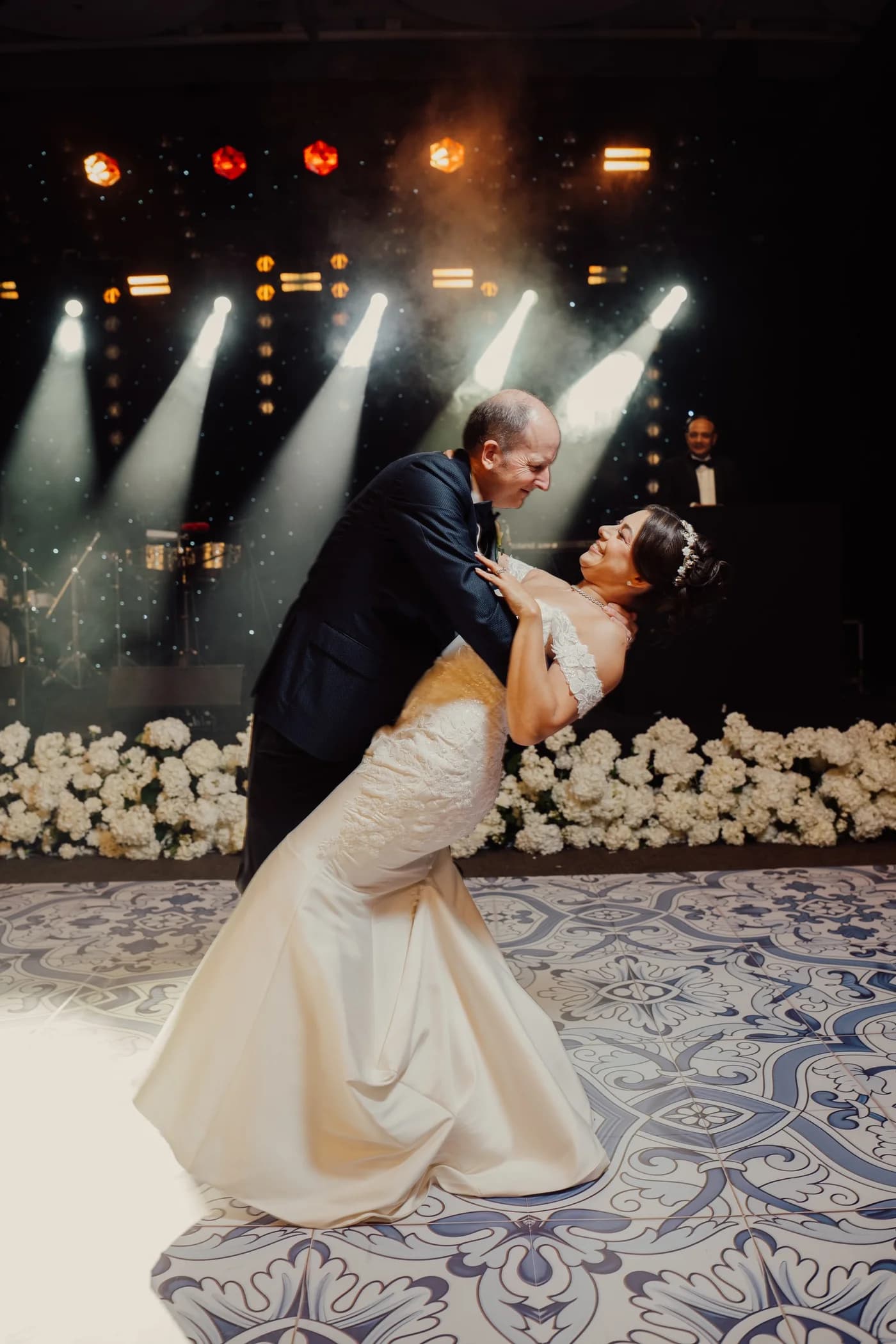 A groom dipping his bride during their choreographed wedding first dance