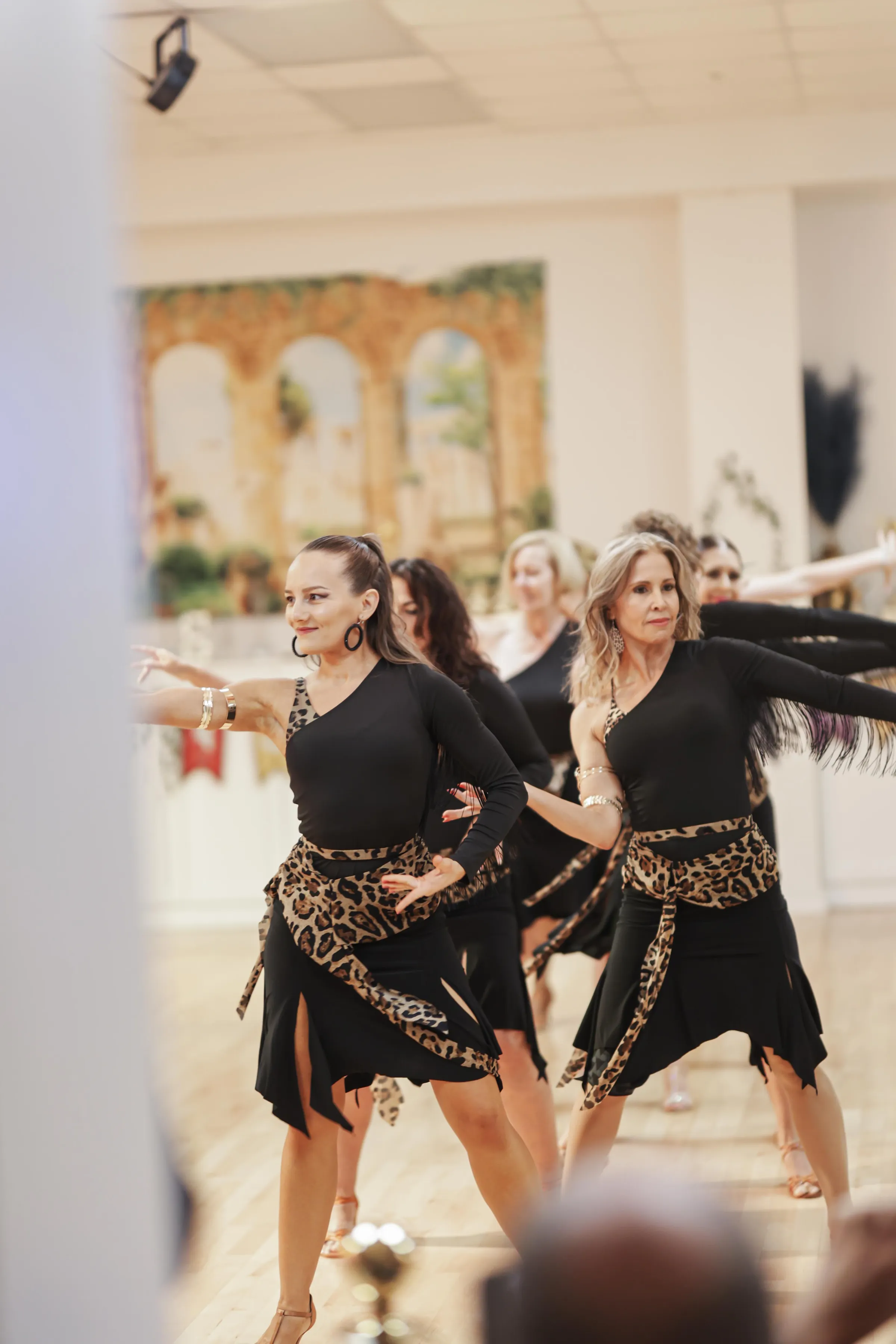 Dancers practicing Latin styling on the bright studio floor at S-Style Dance Team
